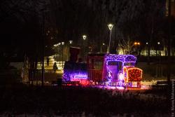 Częściowo oświetlona lokomotywa w parku Jana Pawła II.