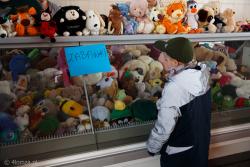 Punkt pomocy Ukraińcom zorganizowany w lokalu po sklepie spożywczym. Pozostawiona lada chłodnicza stała się miejscem prezentacji zabawek. Na zdjęciu ukraiński chłopiec ogląda pluszaki. To początek pomocy, napisy jeszcze języku polskim.