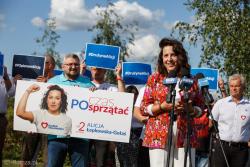 Kandydatka do Sejmu Alicja Łebkowska Gołaś prezentuje swój baner wyborczy i szefa kampanii.